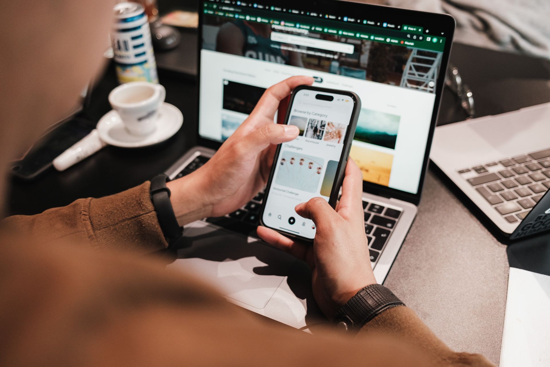 Mãos com smartphone e laptop em espaço de trabalho moderno - MTX Web Studio